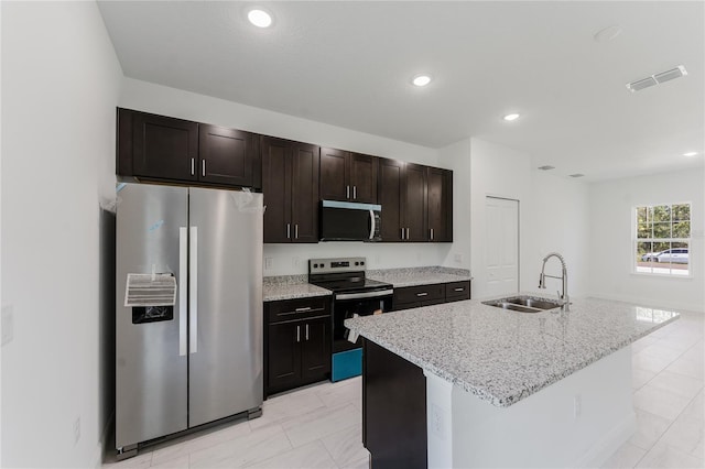 627 W Glenhaven Dr, Citrus Springs, FL 34434 - kitchen featuring stainless steel appliances, light marble finish floors, an island with sink, light stone countertops, and recessed lighting
