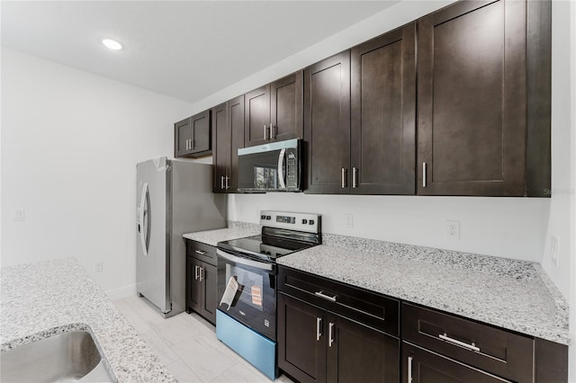 627 W Glenhaven Dr, Citrus Springs, FL 34434 - kitchen featuring stainless steel appliances, dark brown cabinetry, recessed lighting, and light marble finish floors