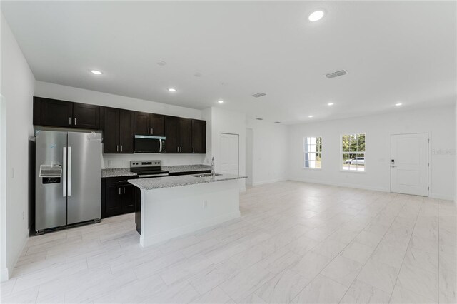 627 W Glenhaven Dr, Citrus Springs, FL 34434 - kitchen featuring stainless steel appliances, a kitchen island with sink, recessed lighting, open floor plan, and light stone counters