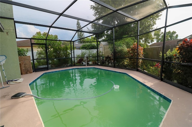 317 Cortez Ct, Kissimmee, FL 34758 - outdoor pool featuring a fenced backyard, a storage unit, a patio area, and glass enclosure