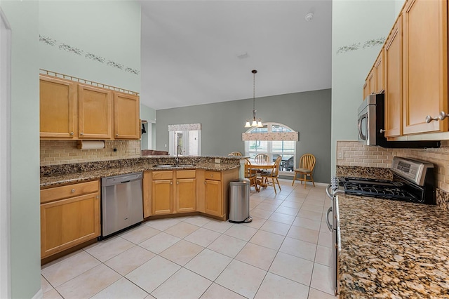 12617 Douglas Fir Ct, Clermont, FL 34711 - kitchen featuring appliances with stainless steel finishes, backsplash, a peninsula, light tile patterned flooring, and high vaulted ceiling