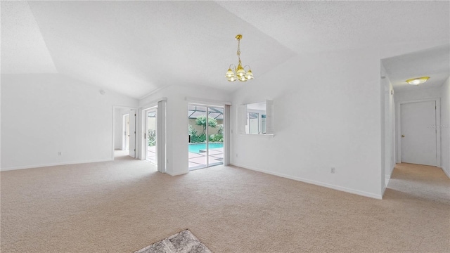 5045 Bermuda Cir Unit 12, Orlando, FL 32808 - unfurnished living room featuring vaulted ceiling, light carpet, and a chandelier