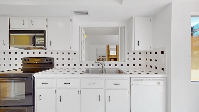 5045 Bermuda Cir Unit 12, Orlando, FL 32808 - kitchen featuring black appliances, backsplash, light countertops, and white cabinetry