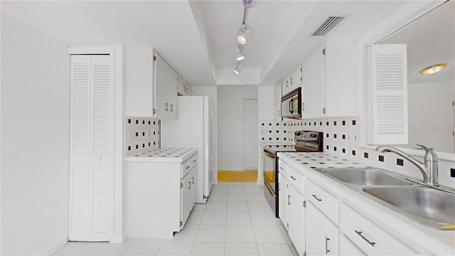5045 Bermuda Cir Unit 12, Orlando, FL 32808 - kitchen featuring appliances with stainless steel finishes, track lighting, decorative backsplash, and white cabinetry