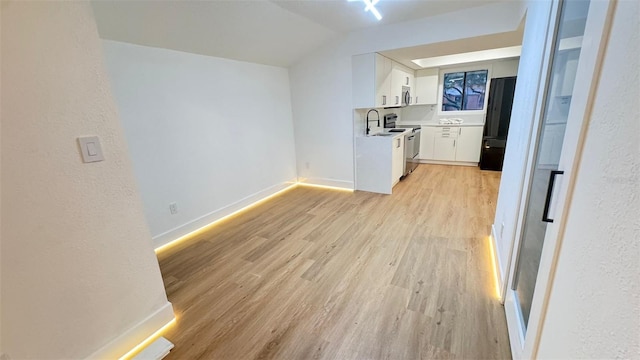 1050 E Michigan St Unit 1050B, Orlando, FL 32806 - unfurnished living room with light wood-type flooring, lofted ceiling, and a textured wall