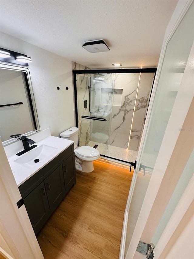 1050 E Michigan St Unit 1050B, Orlando, FL 32806 - bathroom featuring vanity, a marble finish shower, a textured ceiling, and wood finished floors