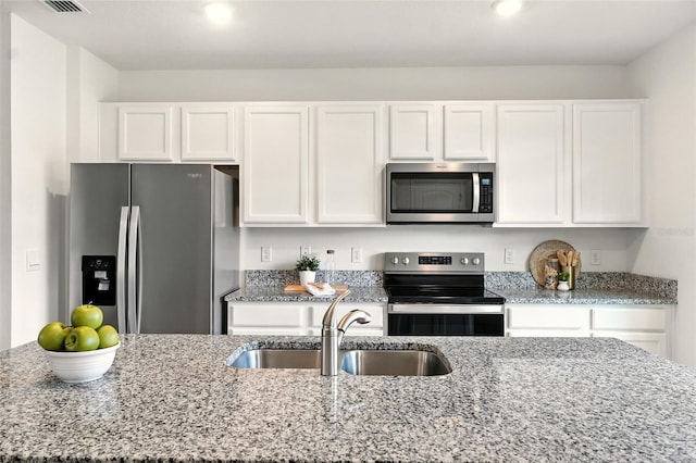 13298 Pontoon Rd, Winter Garden, FL 34787 - kitchen featuring appliances with stainless steel finishes, white cabinetry, and light stone countertops