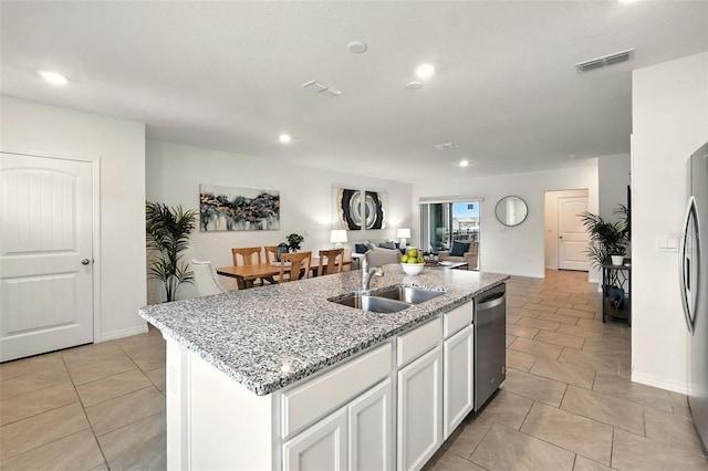 13298 Pontoon Rd, Winter Garden, FL 34787 - kitchen with dishwasher, an island with sink, light tile patterned floors, open floor plan, and white cabinetry