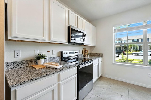 13298 Pontoon Rd, Winter Garden, FL 34787 - kitchen featuring appliances with stainless steel finishes, stone countertops, white cabinetry, and light tile patterned floors