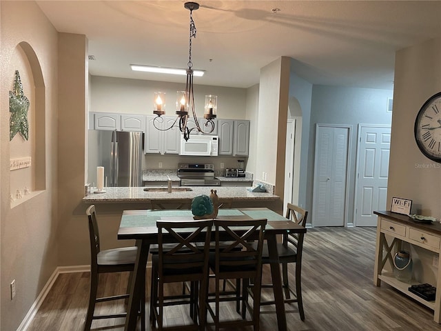 2817 Almaton Loop Unit 403, Kissimmee, FL 34747 - dining room with dark wood-style flooring, arched walkways, and a chandelier