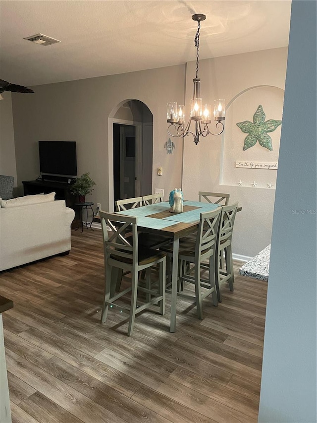 2817 Almaton Loop Unit 403, Kissimmee, FL 34747 - dining room with arched walkways, dark wood-type flooring, and a chandelier