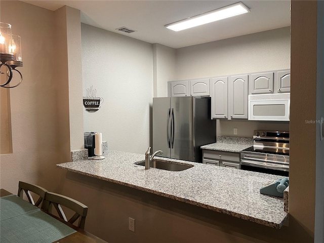 2817 Almaton Loop Unit 403, Kissimmee, FL 34747 - kitchen featuring stainless steel appliances, light stone countertops, and a peninsula