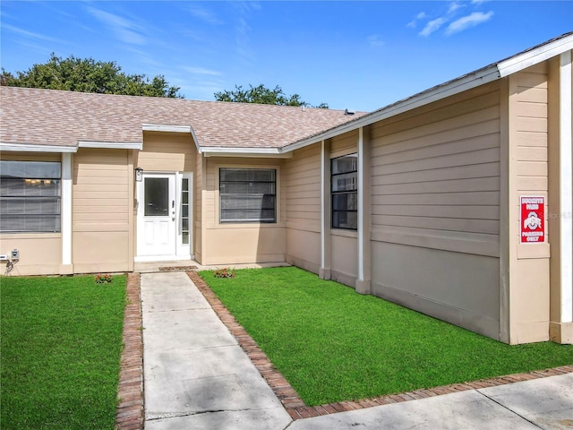 745 Mentmore Cir, Deltona, FL 32738 - doorway to property with a shingled roof and a yard