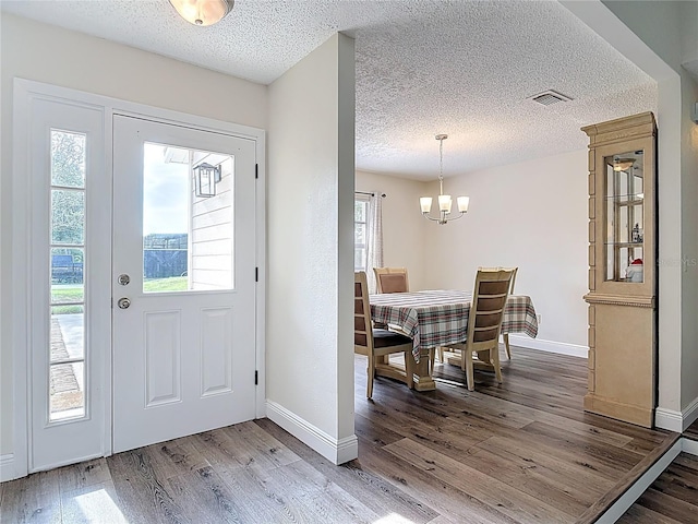 745 Mentmore Cir, Deltona, FL 32738 - foyer entrance with a chandelier, wood finished floors, and a textured ceiling