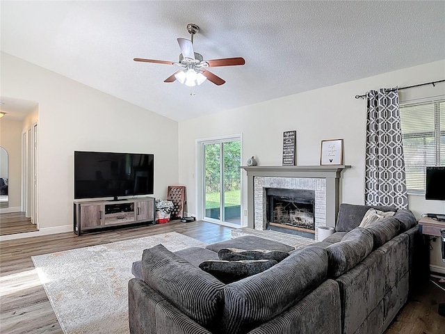 745 Mentmore Cir, Deltona, FL 32738 - living area with vaulted ceiling, wood finished floors, ceiling fan, a fireplace, and a textured ceiling