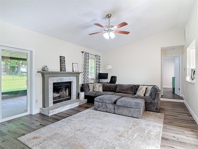 745 Mentmore Cir, Deltona, FL 32738 - living area with a ceiling fan, wood finished floors, a brick fireplace, a textured ceiling, and lofted ceiling