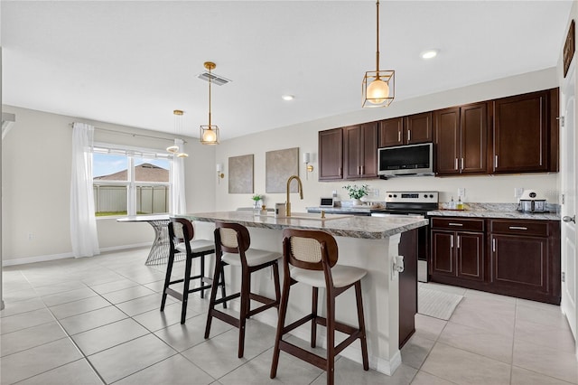 612 Auburn Grove Ter, Auburndale, FL 33823 - kitchen with appliances with stainless steel finishes, a kitchen breakfast bar, light tile patterned floors, hanging light fixtures, and recessed lighting