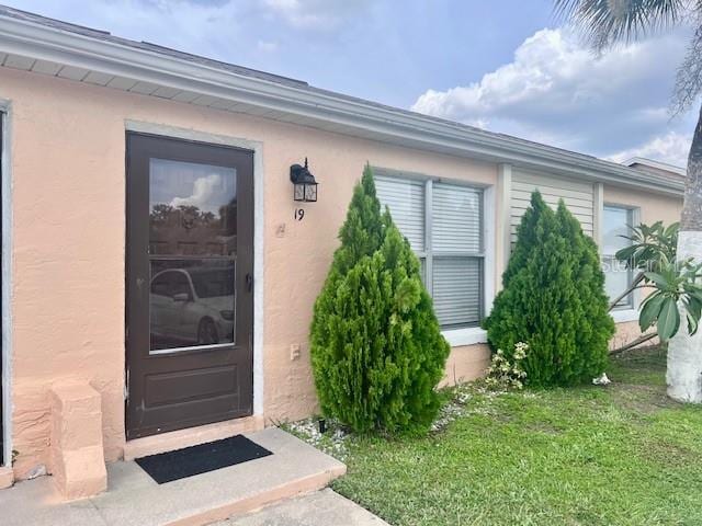 19 W Country Cove Way, Kissimmee, FL 34743 - property entrance with a yard and stucco siding
