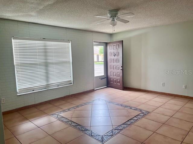 19 W Country Cove Way, Kissimmee, FL 34743 - tiled spare room with ceiling fan and a textured ceiling