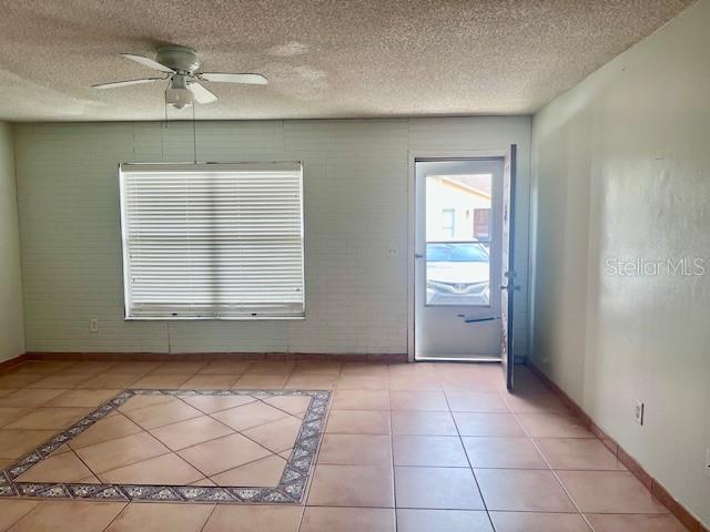 19 W Country Cove Way, Kissimmee, FL 34743 - empty room featuring a ceiling fan, a textured ceiling, and light tile patterned floors