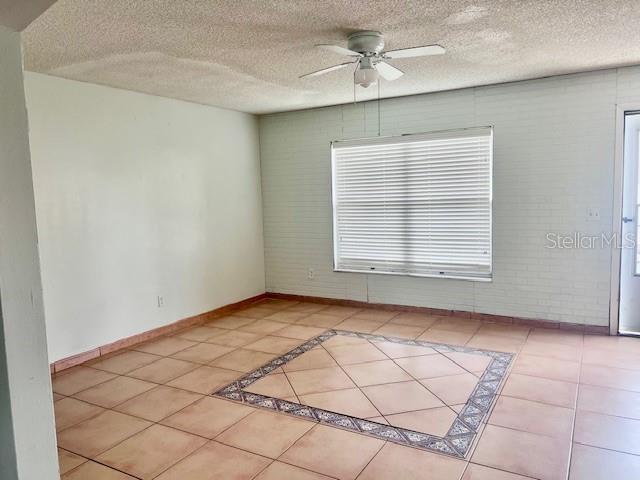 19 W Country Cove Way, Kissimmee, FL 34743 - tiled spare room featuring ceiling fan and a textured ceiling