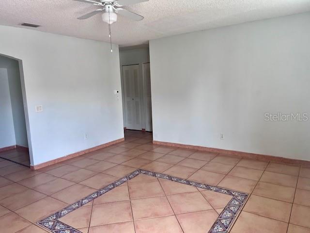 19 W Country Cove Way, Kissimmee, FL 34743 - unfurnished room with a ceiling fan, a textured ceiling, and tile patterned floors