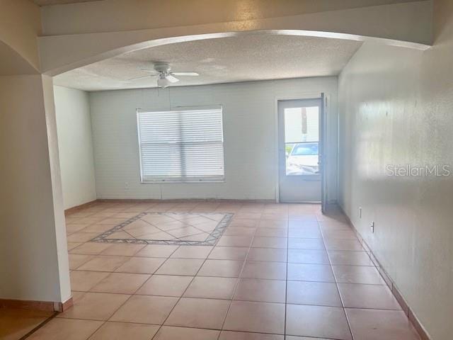 19 W Country Cove Way, Kissimmee, FL 34743 - spare room featuring ceiling fan, light tile patterned flooring, and arched walkways