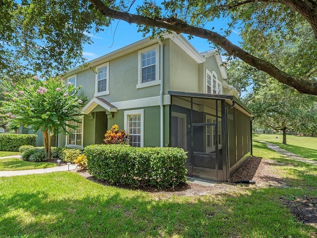 741 Ashworth Overlook Dr Unit B, Apopka, FL 32712 - view of side of property with a sunroom, stucco siding, and a lawn