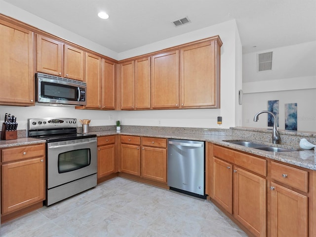 741 Ashworth Overlook Dr Unit B, Apopka, FL 32712 - kitchen with appliances with stainless steel finishes, light stone countertops, brown cabinetry, and recessed lighting