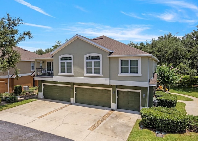 741 Ashworth Overlook Dr Unit B, Apopka, FL 32712 - view of front facade featuring stucco siding, an attached garage, concrete driveway, and a shingled roof