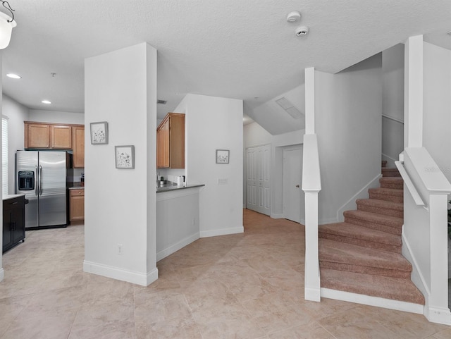 741 Ashworth Overlook Dr Unit B, Apopka, FL 32712 - kitchen featuring stainless steel fridge, brown cabinets, recessed lighting, and a textured ceiling