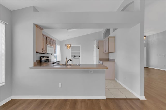 3507 Tenby Cir, Clermont, FL 34711 - kitchen with stainless steel range with electric cooktop, white microwave, vaulted ceiling, a peninsula, and light countertops