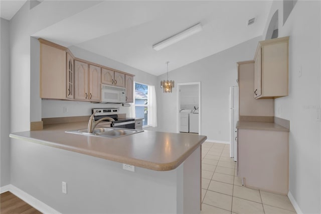 3507 Tenby Cir, Clermont, FL 34711 - kitchen featuring white microwave, washer and clothes dryer, electric range oven, vaulted ceiling, and a peninsula