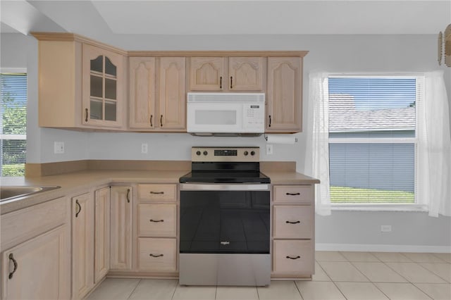 3507 Tenby Cir, Clermont, FL 34711 - kitchen featuring white microwave, stainless steel range with electric stovetop, light brown cabinets, light countertops, and glass insert cabinets