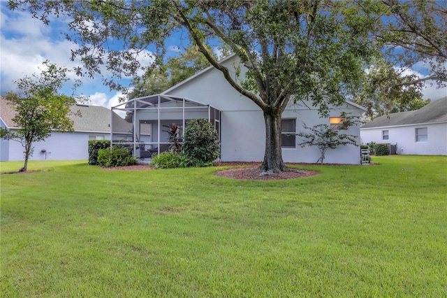 3507 Tenby Cir, Clermont, FL 34711 - back of property with a yard, stucco siding, and glass enclosure