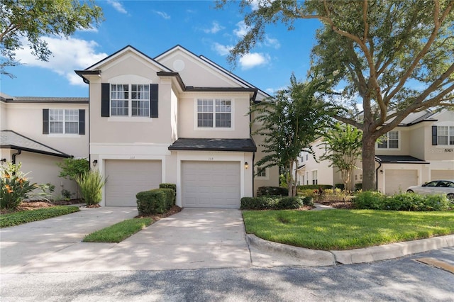 6059 Twain St Unit 108, Orlando, FL 32835 - traditional-style home with stucco siding, a garage, driveway, and a front lawn