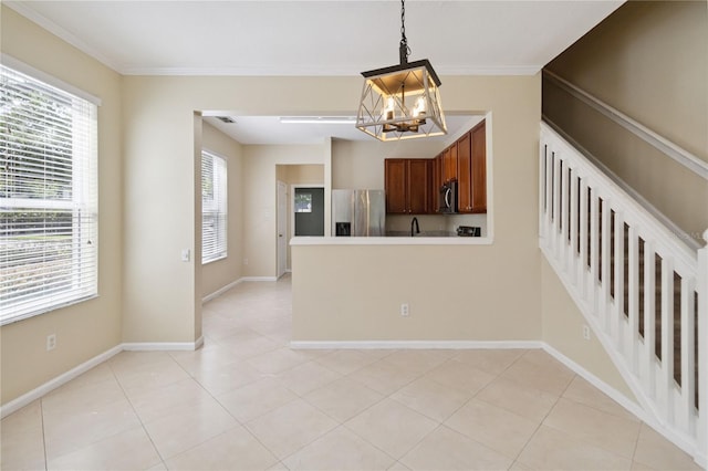 6059 Twain St Unit 108, Orlando, FL 32835 - kitchen featuring stainless steel fridge, a chandelier, plenty of natural light, hanging light fixtures, and ornamental molding