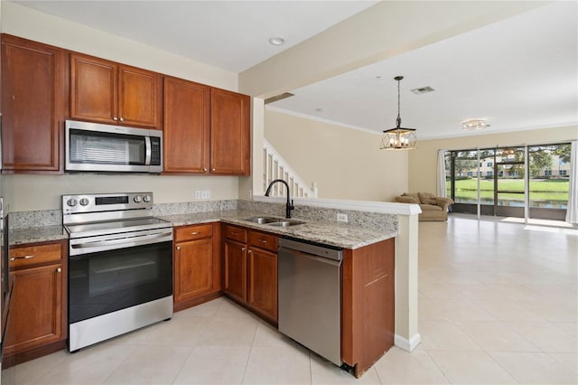 6059 Twain St Unit 108, Orlando, FL 32835 - kitchen with appliances with stainless steel finishes, open floor plan, a peninsula, light stone counters, and a chandelier
