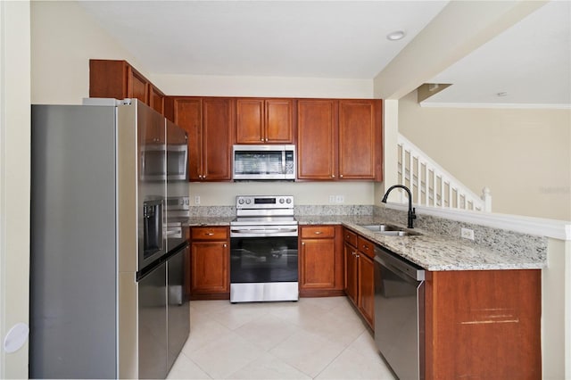 6059 Twain St Unit 108, Orlando, FL 32835 - kitchen with appliances with stainless steel finishes, a peninsula, light stone counters, light tile patterned floors, and brown cabinets