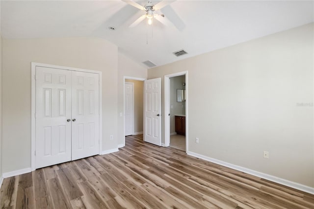 6059 Twain St Unit 108, Orlando, FL 32835 - unfurnished bedroom with a closet, wood finished floors, vaulted ceiling, a ceiling fan, and ensuite bathroom