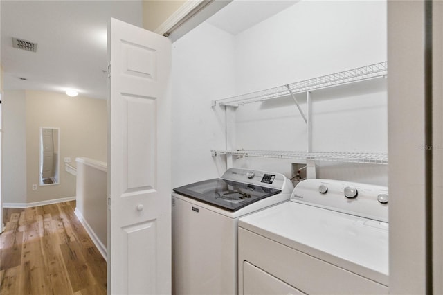 6059 Twain St Unit 108, Orlando, FL 32835 - laundry room featuring washing machine and dryer and light wood finished floors