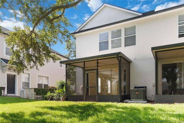 6059 Twain St Unit 108, Orlando, FL 32835 - rear view of house with a sunroom, a lawn, and stucco siding