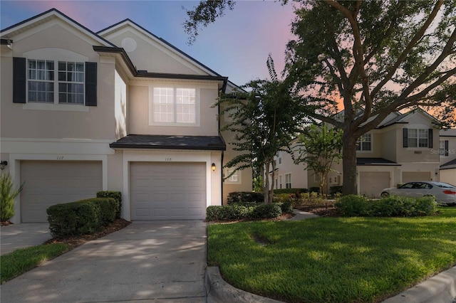 6059 Twain St Unit 108, Orlando, FL 32835 - traditional home featuring an attached garage, stucco siding, concrete driveway, and a yard