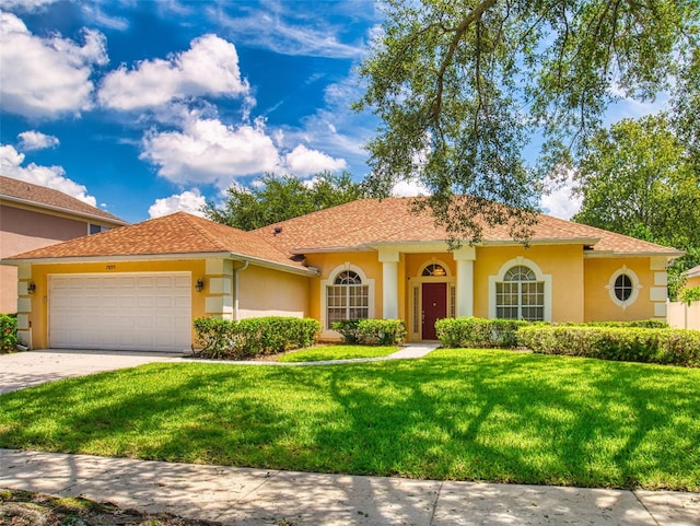 7985 Saint Giles Pl, Orlando, FL 32835 - view of front of property featuring an attached garage, a front yard, stucco siding, and driveway
