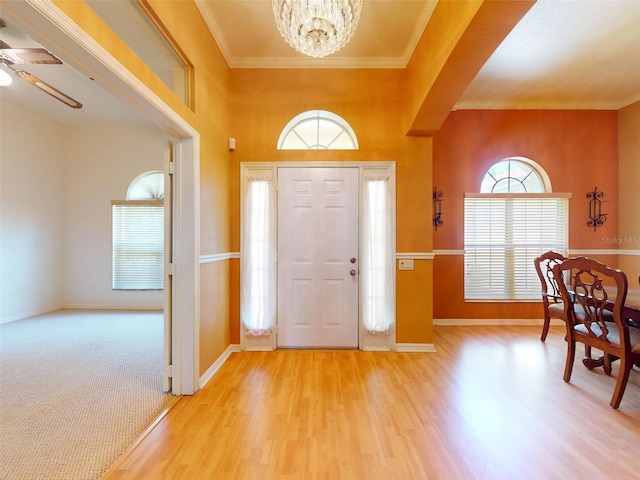 7985 Saint Giles Pl, Orlando, FL 32835 - foyer entrance with light wood-style floors, a chandelier, ornamental molding, and ceiling fan