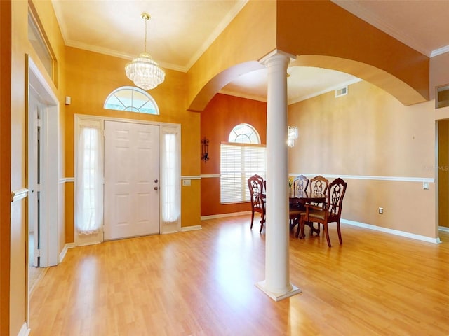 7985 Saint Giles Pl, Orlando, FL 32835 - foyer entrance with arched walkways, wood finished floors, a chandelier, crown molding, and ornate columns