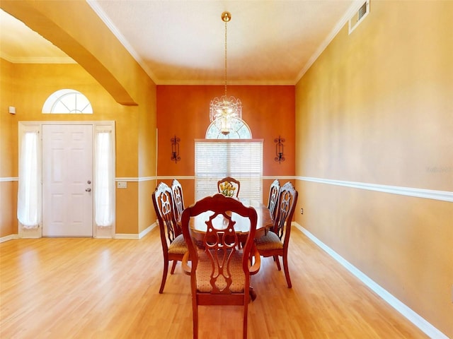 7985 Saint Giles Pl, Orlando, FL 32835 - dining room featuring wood finished floors, plenty of natural light, crown molding, and a chandelier