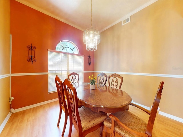 7985 Saint Giles Pl, Orlando, FL 32835 - dining area featuring wood finished floors, crown molding, and a chandelier