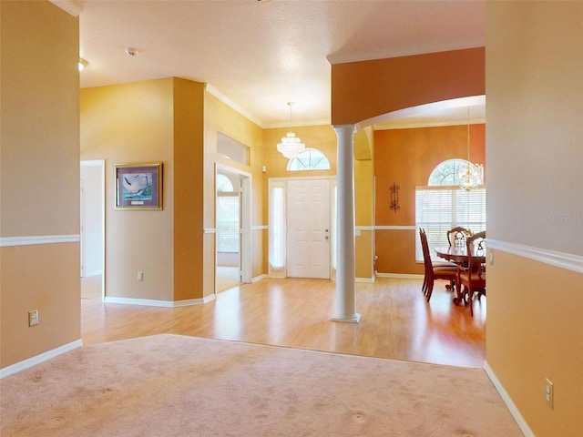 7985 Saint Giles Pl, Orlando, FL 32835 - carpeted entryway featuring a chandelier, decorative columns, and crown molding