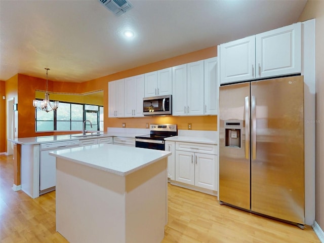 7985 Saint Giles Pl, Orlando, FL 32835 - kitchen with appliances with stainless steel finishes, a peninsula, light wood finished floors, light countertops, and recessed lighting